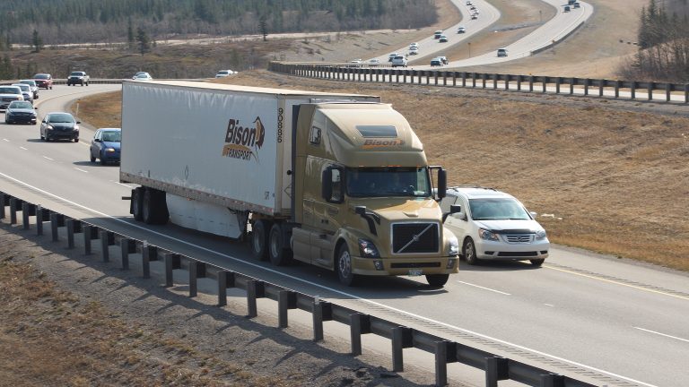 Transport truck on a divided highway beside a car