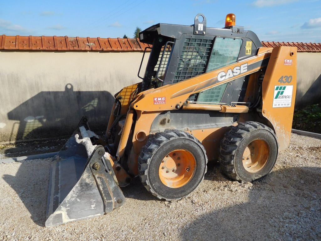 Side view of a wheeled skid-steer loader with a general purpose bucket